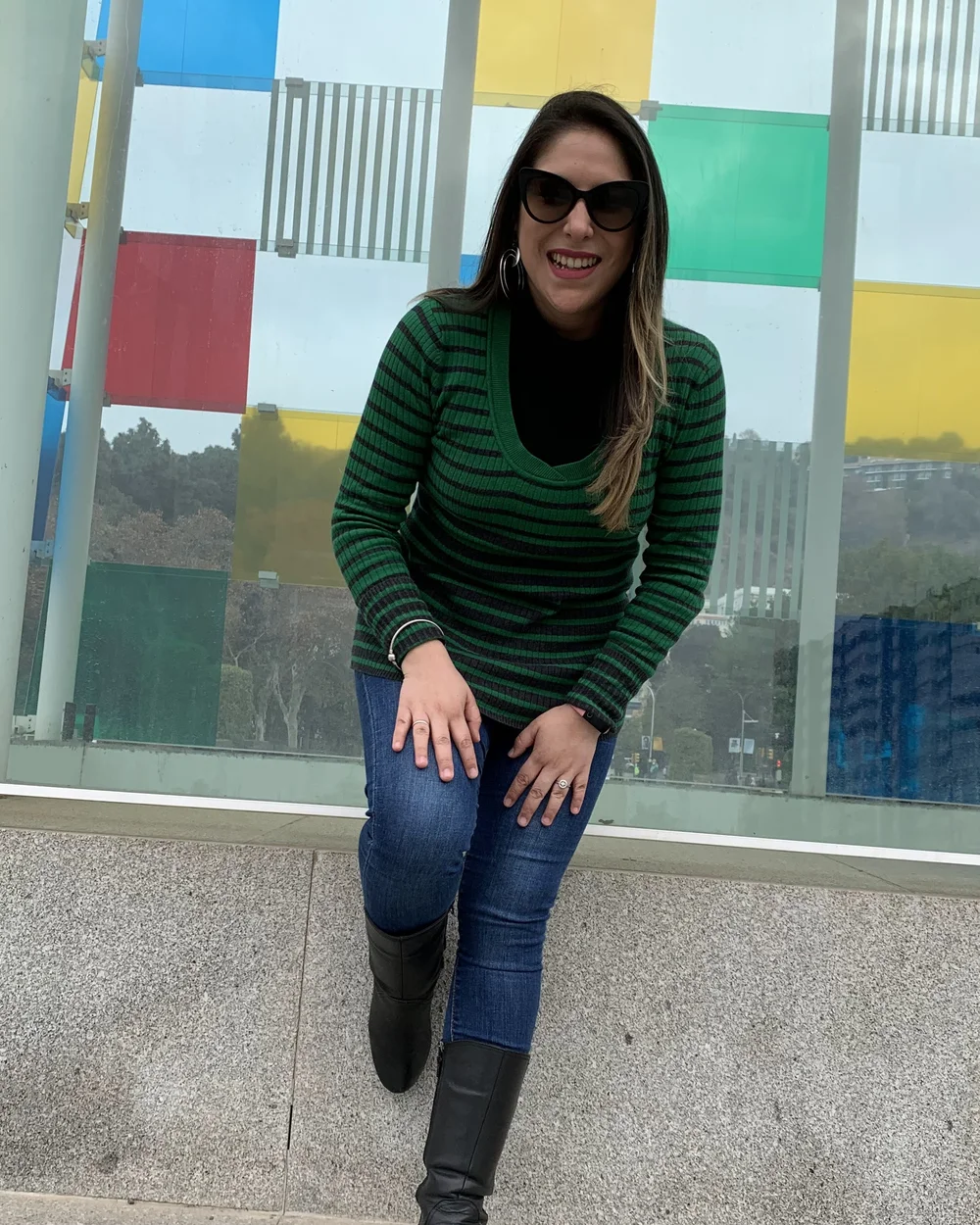 Cris sonriendo con jersey verde delante de una pared de cristales de colores
