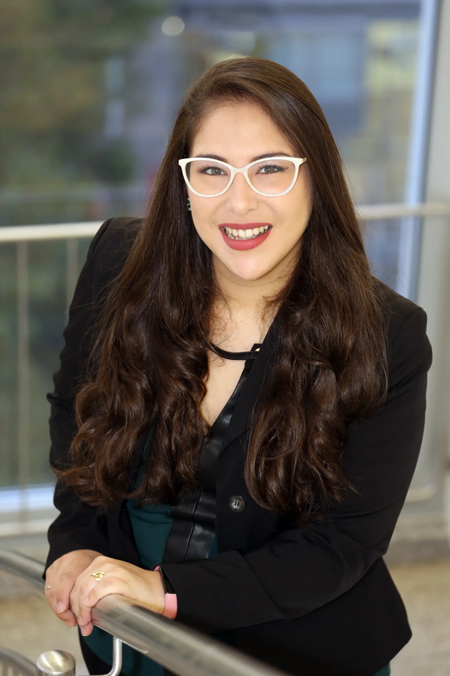Cris Toledo sonriendo, con gafas blancas y americana negra